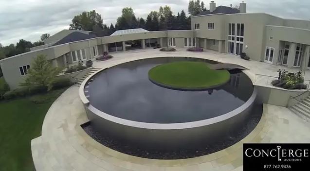 An infinity pool on the outside patio includes a small grass section for sunbathing