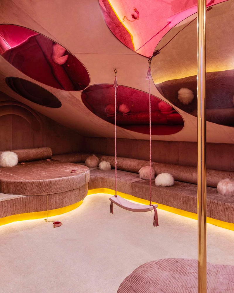 A pink room with stripper pole and swing